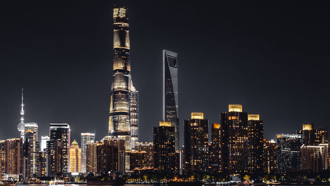 Illustrative image: Shanghai skyline illuminated against the night sky featuring iconic skyscrapers.