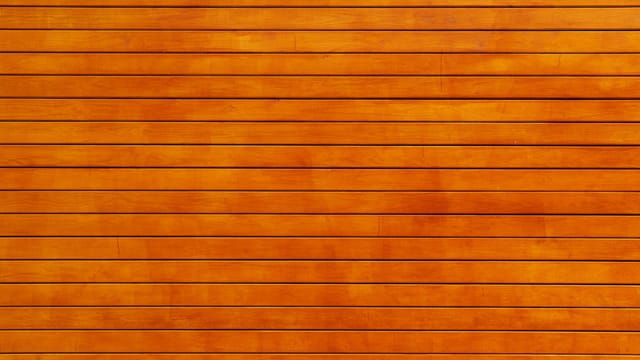 Close-up of a vibrant orange wooden wall texture, ideal for backgrounds.