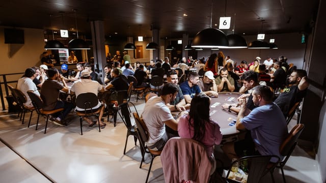 Intense poker game in a lively casino with multiple players. Experience the thrill and strategy of poker.