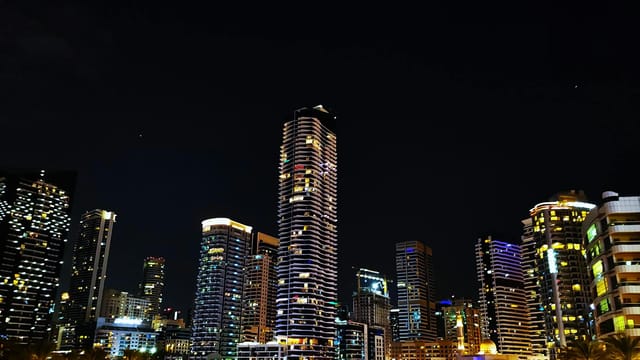 Stunning night view of the Dubai Marina skyline with illuminated skyscrapers reflecting urban vibrancy.