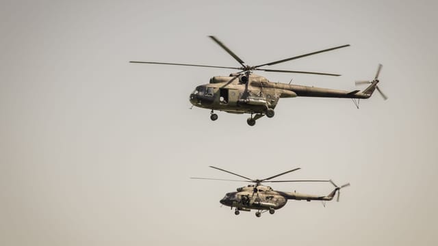 Two military helicopters flying in formation in the clear sky over Belgrade, showcasing aerial power.
