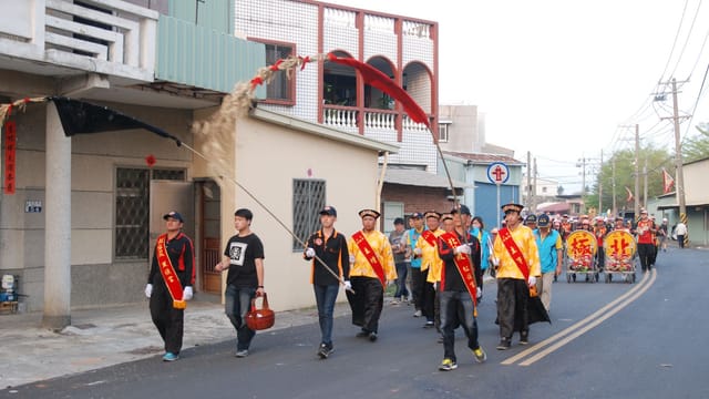 A vibrant outdoor parade showcasing traditional cultural attire and banners.