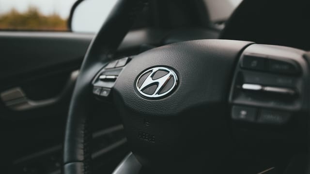 A close-up image focusing on a Hyundai steering wheel inside a car, highlighting design details.