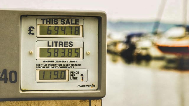 Blurred background view with focus on fuel pump display showing price and liters.