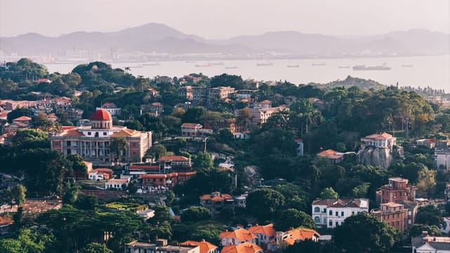 A stunning aerial view of Gulangyu Island with vibrant architecture and surrounding sea in Xiamen, China.