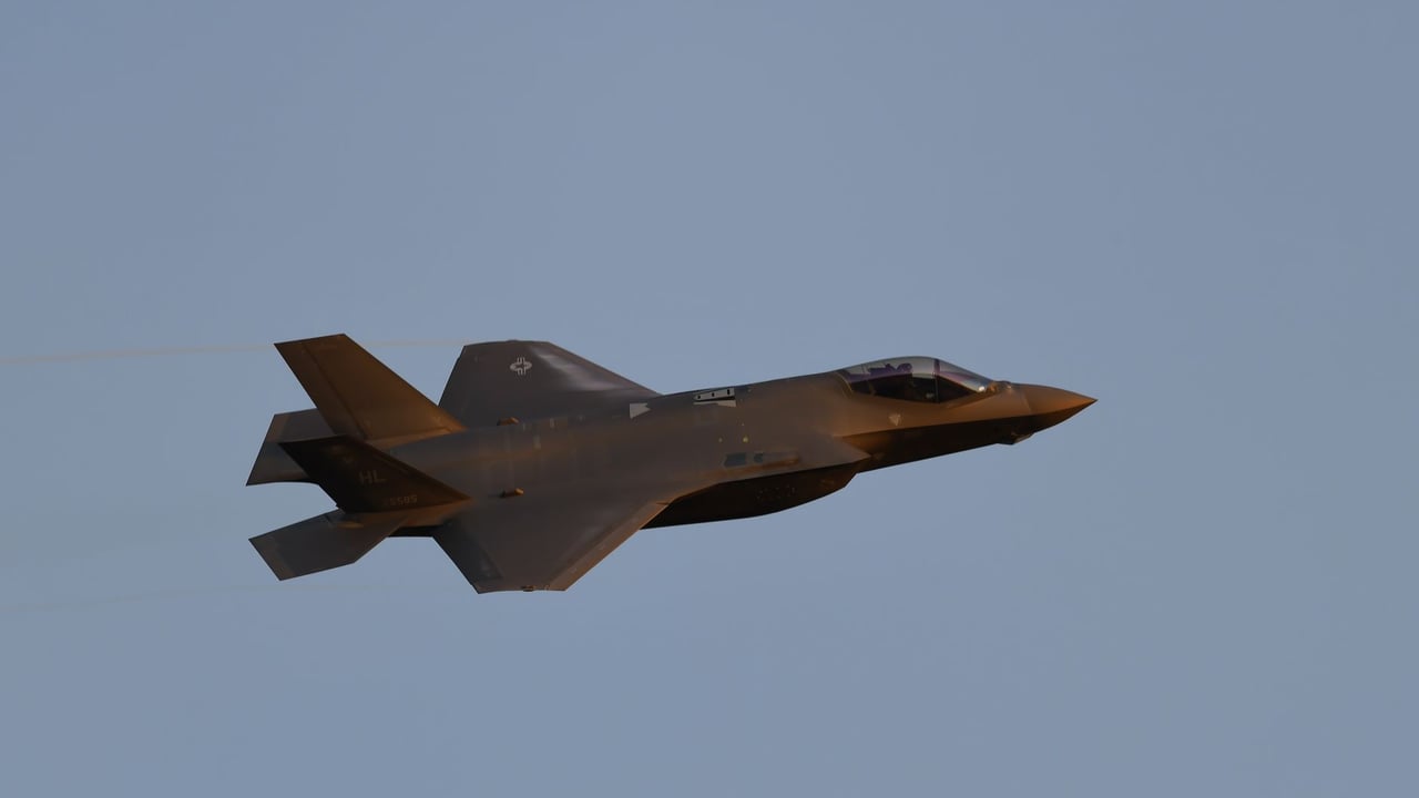 Sleek jet fighter aircraft soaring against a clear blue sky at high speed.