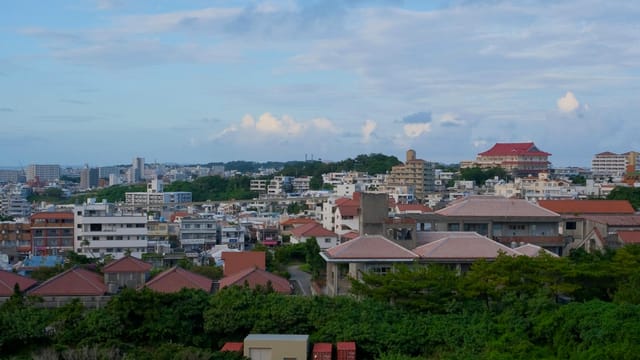 Panoramic view of Okinawa cityscape with traditional and modern buildings.