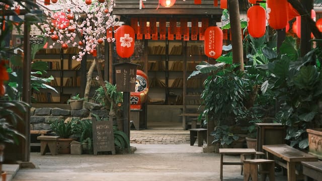 Serene Asian courtyard adorned with red lanterns, plants, and traditional decor.