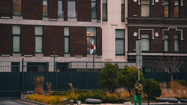 Exterior of the Japanese Embassy in Kyiv, featuring the national flag and urban landscape.