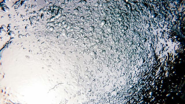 Captivating underwater bubbles creating a swirling pattern near Adicora, Venezuela.