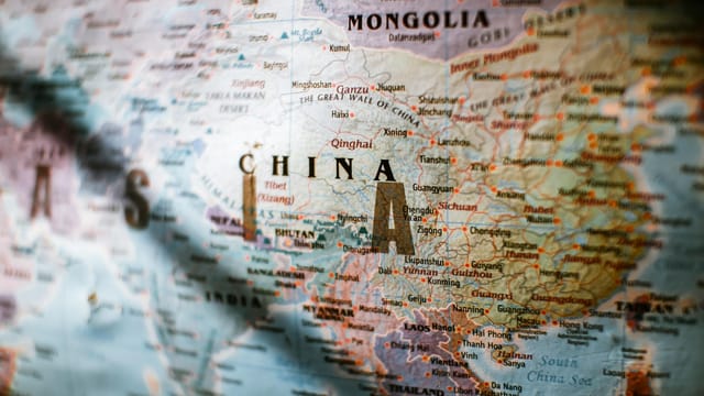 Paper political world map with Asian countries borders and coastline near water