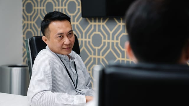 Two professionals engaged in a discussion during a business meeting in a modern office setting.
