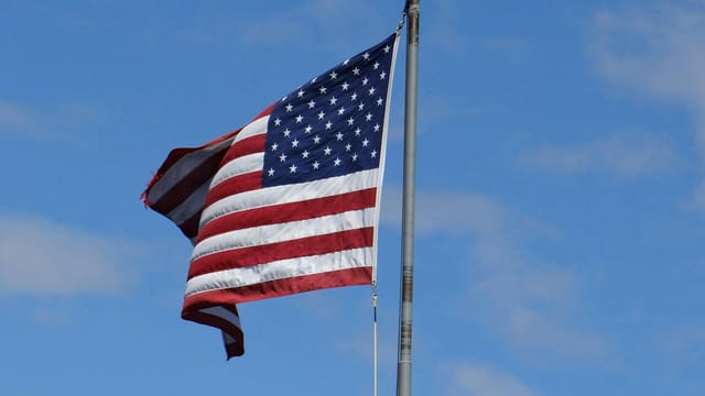 US flag flying in clear blue sky at Mackinac Island, MI. Symbol of American patriotism.