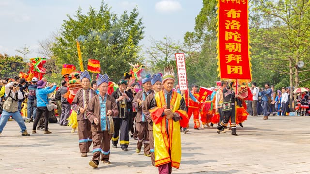 Vibrant parade in Guangxi, China featuring traditional costumes and cultural banners.