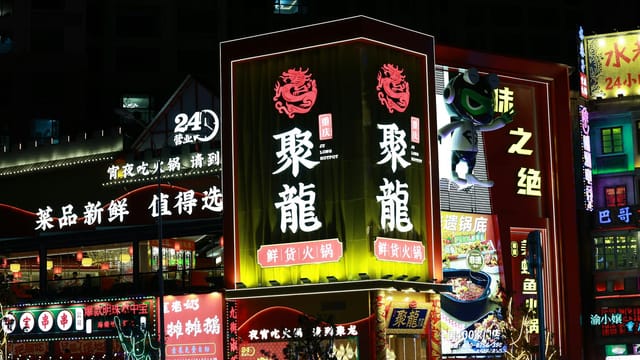 Captivating urban scene with neon signs illuminating a lively Asian street at night.