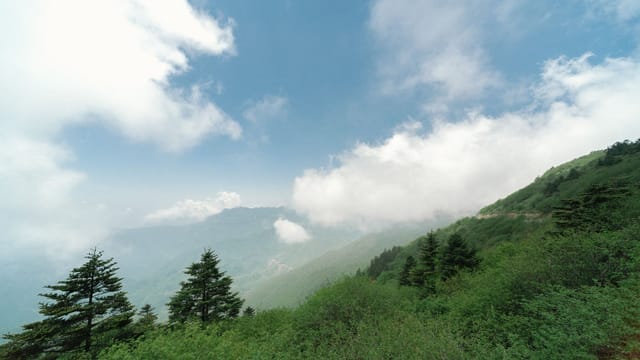 Expansive view of lush green mountains and sky in Enshi City, Hubei, ideal for nature lovers.
