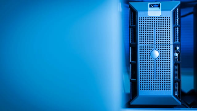 Close-up of a modern server unit in a blue-lit data center environment.