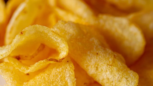 Delicious close-up of crispy golden potato chips, perfect snack option.
