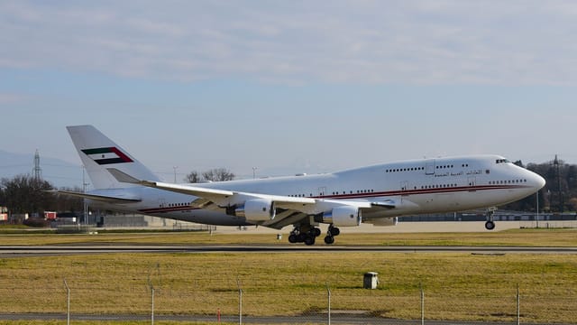 A large commercial aircraft preparing for takeoff at Geneva Airport on a clear day.