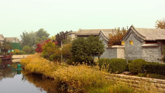 Traditional architecture and serene riverside landscape in Beijing, China captured on a calm day.