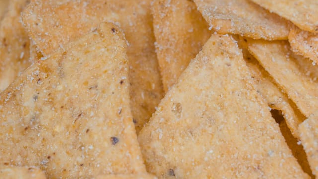 A macro view of crunchy, salted corn chips, perfect snack delicacy.