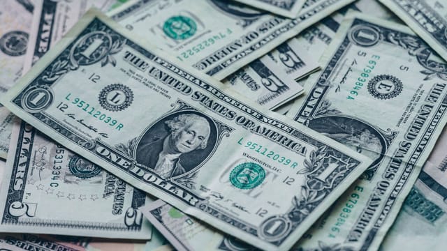Close-up image of stacked US dollar bills representing wealth and finance.