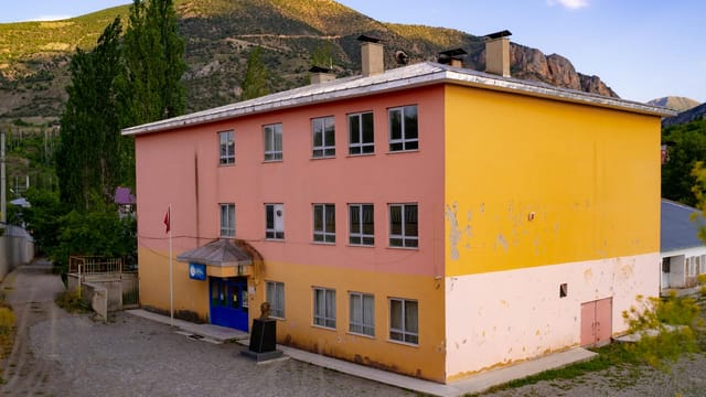 A vibrant building in the countryside of Erzurum, Türkiye, under a clear sky.