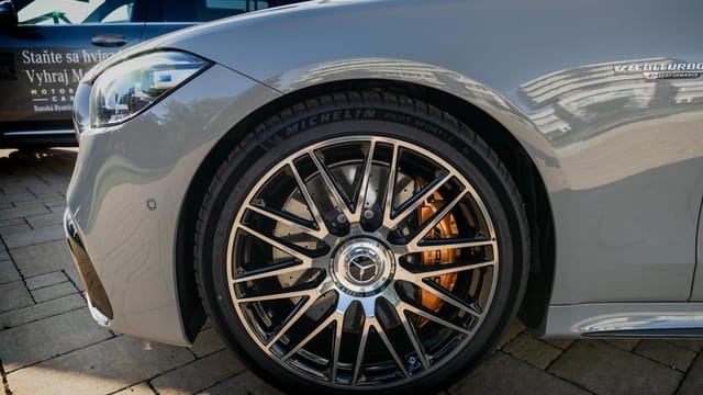 Detailed view of a Mercedes-Benz AMG wheel with V8 Biturbo badge in a city environment.