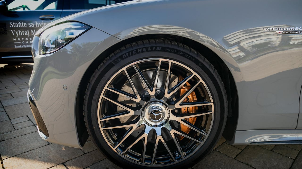 Detailed view of a Mercedes-Benz AMG wheel with V8 Biturbo badge in a city environment.