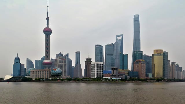 A stunning view of the modern Shanghai skyline with the iconic Oriental Pearl Tower across the waterfront.