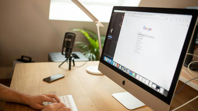 A modern workspace with an iMac displaying Google search, perfect for remote work setups.