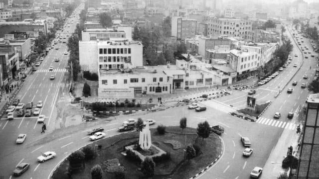 Black and white aerial view of Alborz city with bustling streets and roundabout.