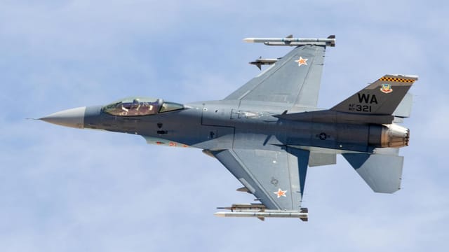 F-16 jet flying over Nellis Air Force Base, Nevada, showcasing its sleek design and power.