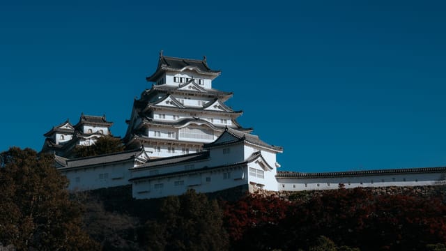 Stunning view of Himeji Castle with clear blue sky, highlighting its white façade and traditional Japanese architecture.
