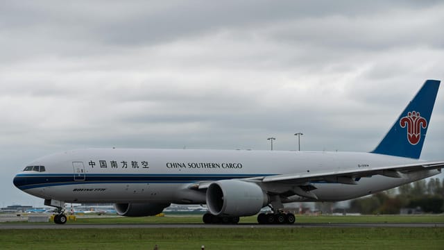 China Southern Cargo Boeing 777 aircraft taxiing on runway under cloudy skies.