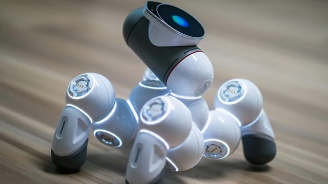 Close-up of a futuristic robot toy on a wooden floor, showcasing modern innovation.