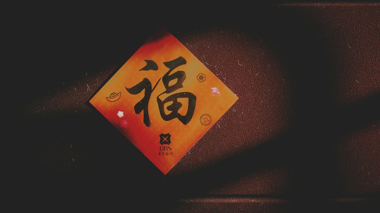 Close-up of a Chinese character card on a textured brown wall with shadows.