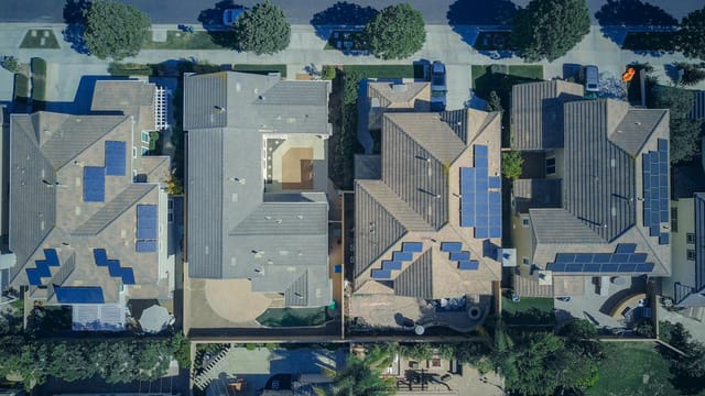 Top-down view of urban houses with solar panels emphasizing clean energy solutions.
