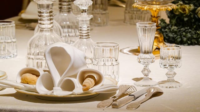An elegantly set dining table with crystal glassware and ornate decor, ideal for formal occasions.