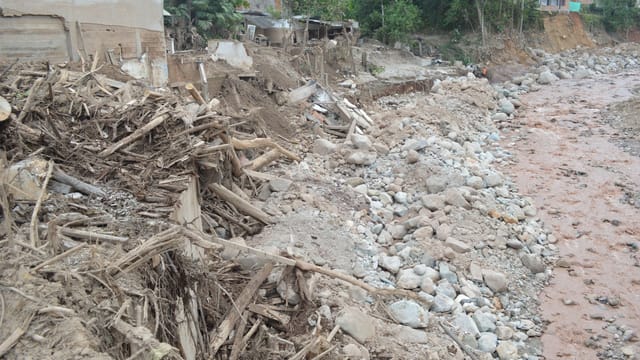 Erosion and debris visible along the dried riverbed in Mocoa, Colombia.