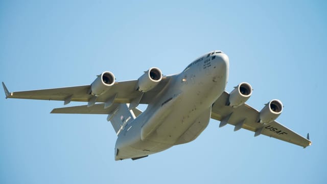 US Air Force C-17 Globemaster aircraft flying low in clear blue sky over Fairfield, California.