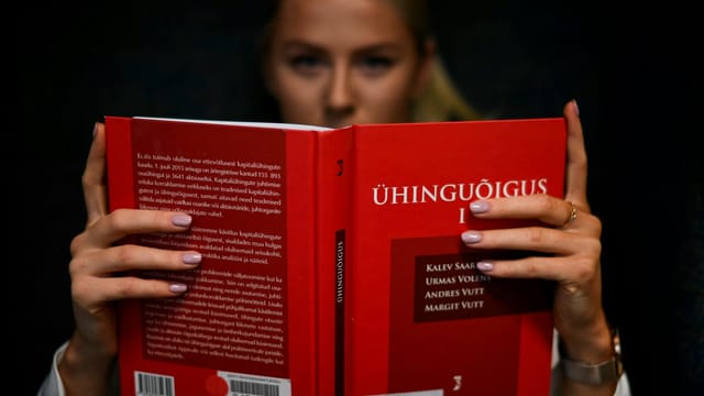 A law student intensely reading a legal textbook indoors in Tallinn, Estonia.