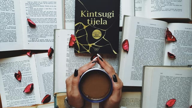 A serene scene featuring a book, cup of coffee, and scattered rose petals, perfect for relaxation themes.