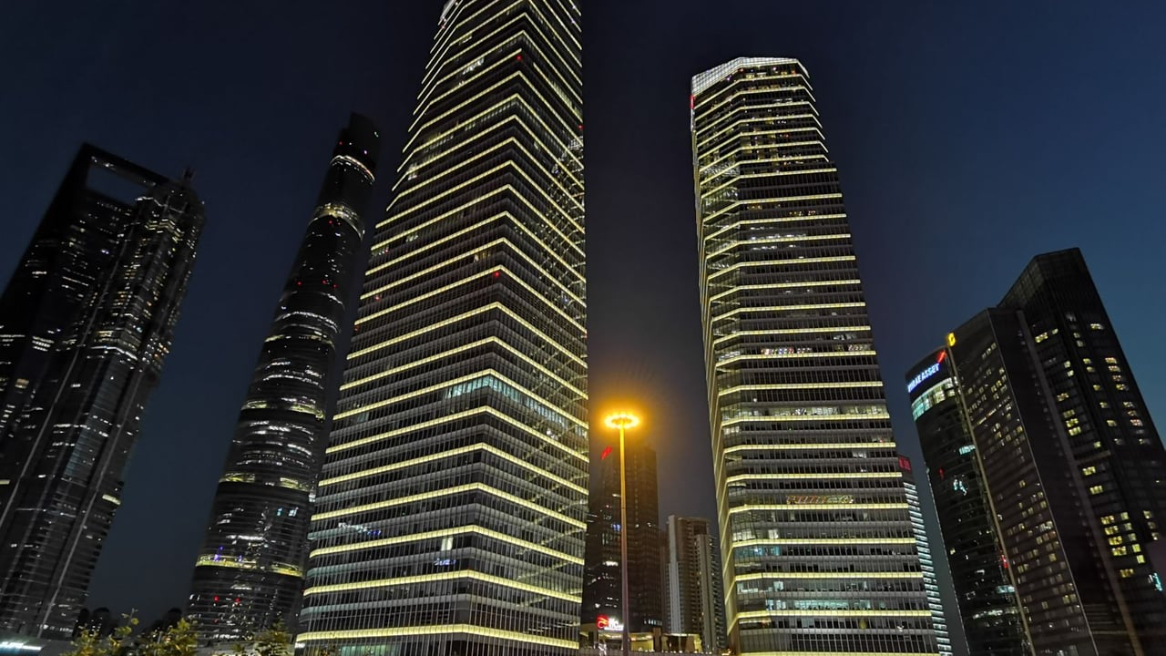 Night view of Shanghai's illuminated skyscrapers showcasing modern urban architecture.