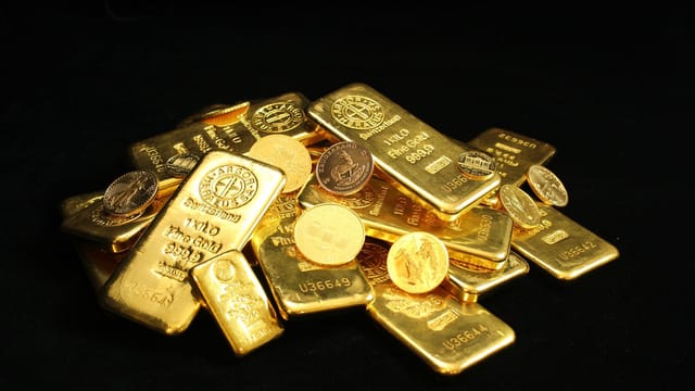 Close-up of shiny gold bars and coins symbolizing wealth and prosperity.