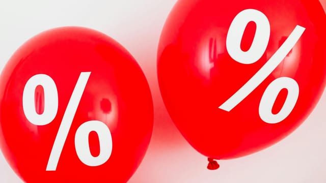 Red balloons featuring percentage symbols, ideal for sales and promotions.
