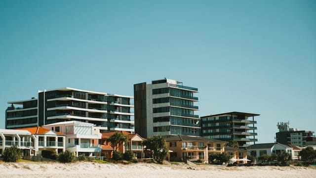 A beachfront view of modern buildings in the Gold Coast, showcasing urban architecture against a clear sky.