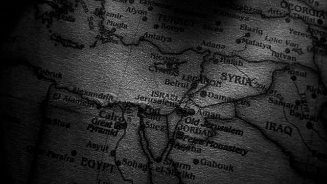 Close-up grayscale image of a map showing countries in the Middle East, including Egypt, Syria, and Iraq.