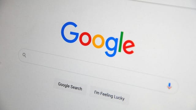 Close-up of the Google homepage on a screen showing search options.