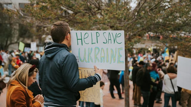 A peace rally in San Francisco with protesters holding signs supporting Ukraine.